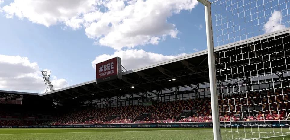 Goalpost with stadium backdrop and cloudy sky