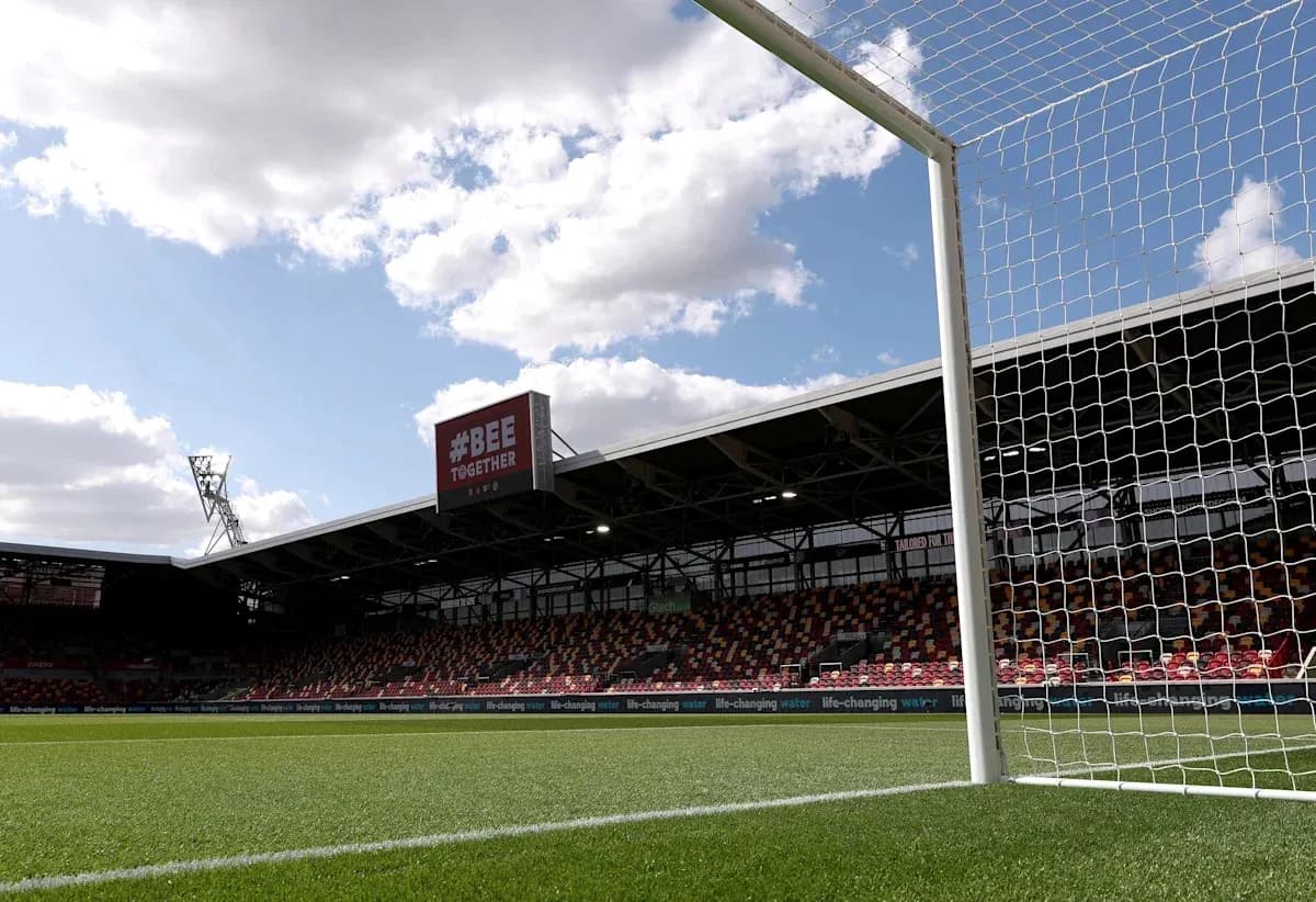 Goalpost with stadium backdrop and cloudy sky