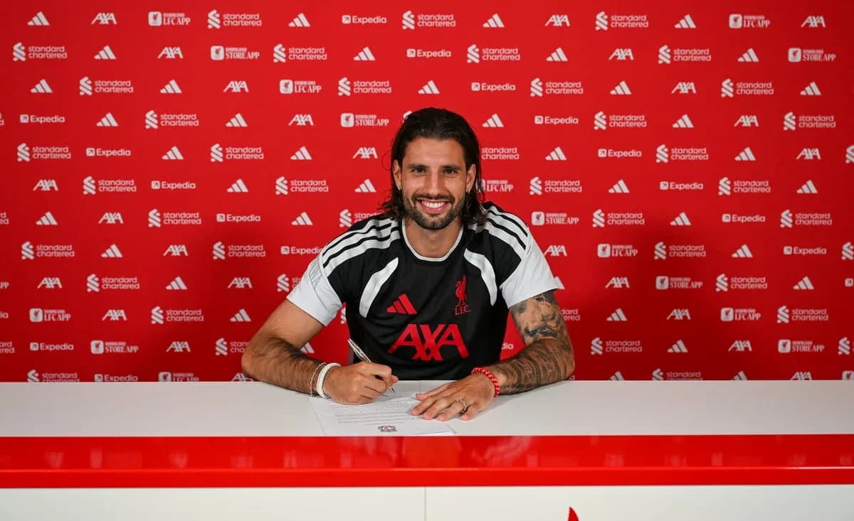 Futbolçu müqavilə imzalayarkən masada oturub