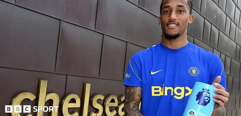 Futbolçu Chelsea loqosunun yanında mükafat tutur