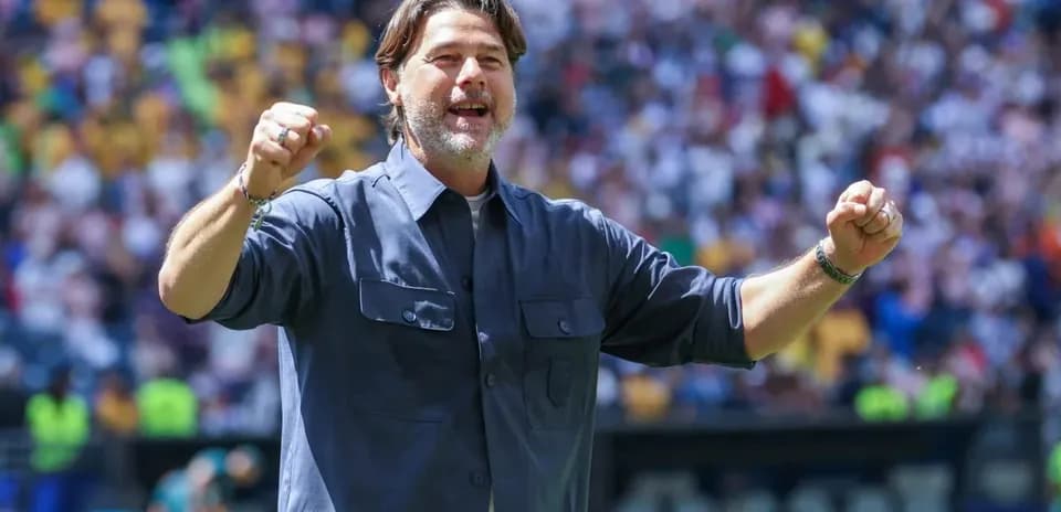 Coach celebrating with raised fists at stadium
