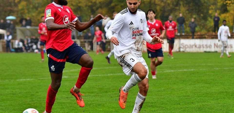 Futbol meydanında iki oyunçu mübarizə aparır