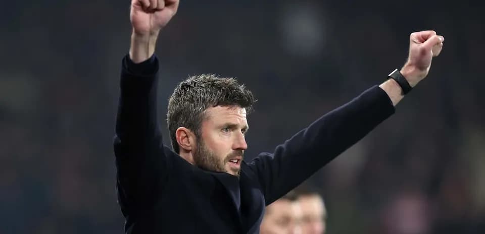 Men's football coach celebrating with raised arms