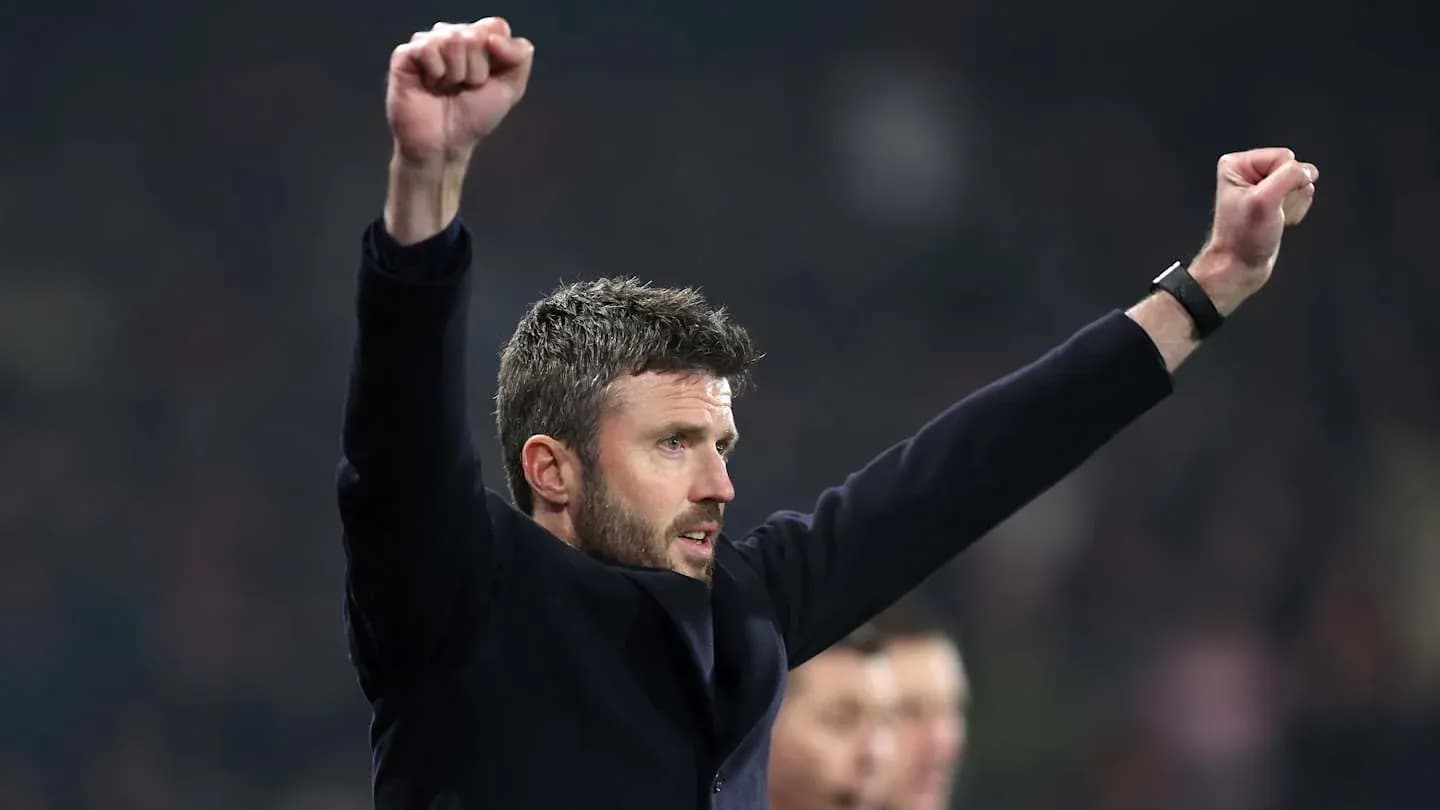 Men's football coach celebrating with raised arms