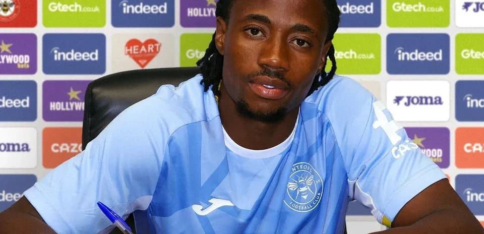 Futbolçu imza atarkən masada oturur