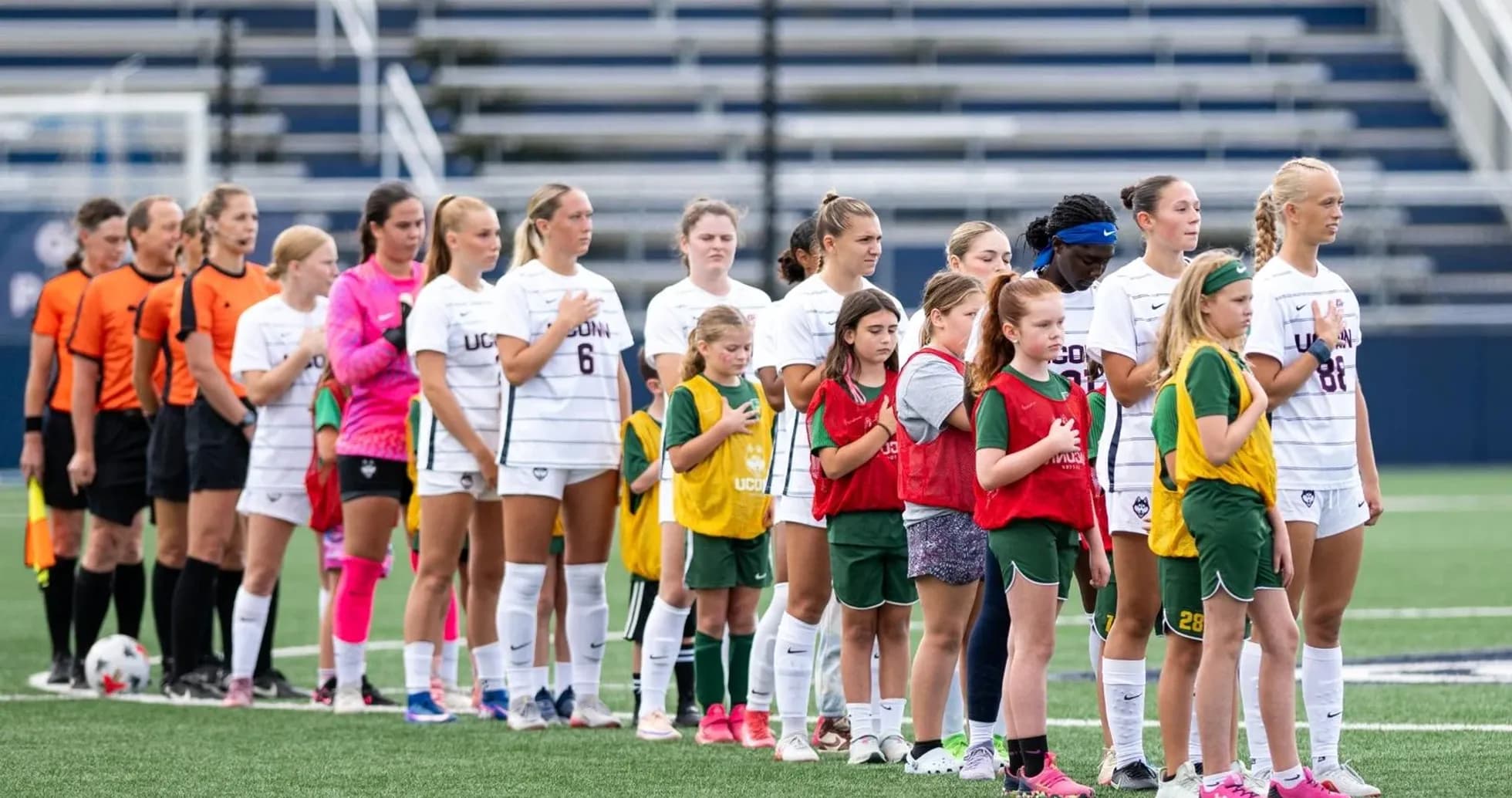 UConn women's soccer team and youth players during anthem