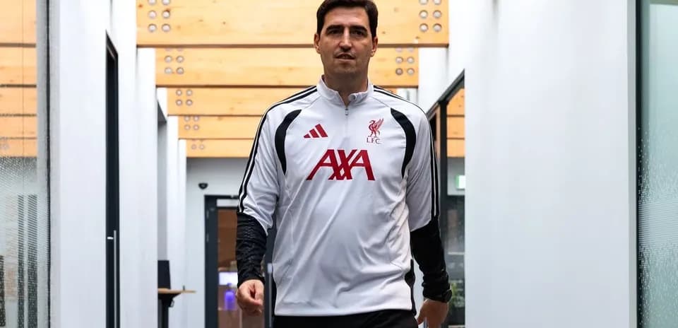 Football player in Liverpool training gear walking indoors