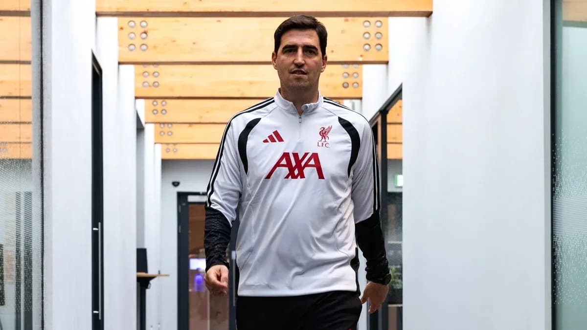 Football player in Liverpool training gear walking indoors