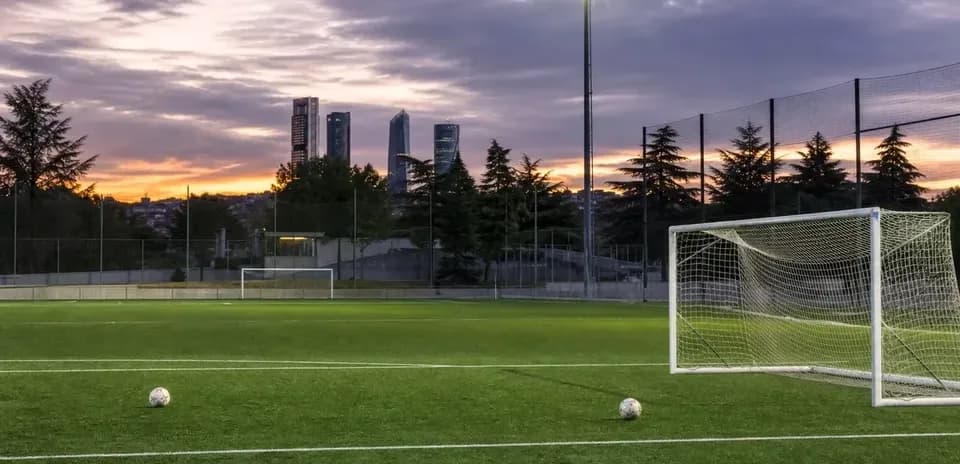 Football field with goalposts and sunset skyline