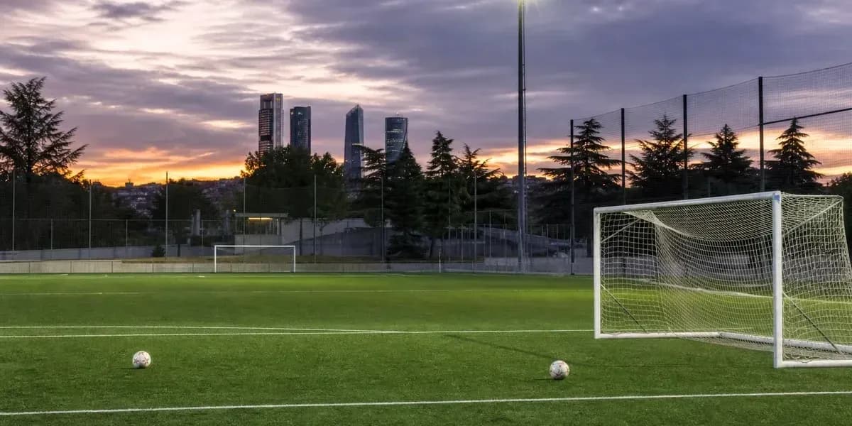 Football field with goalposts and sunset skyline