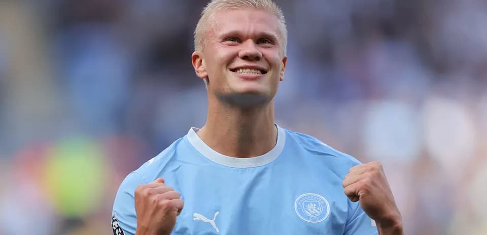 Futbolçu sevinclə əlini sıxır, Manchester City formasıda