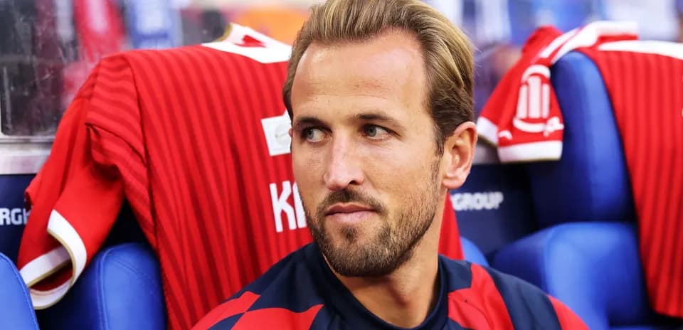 Futbolçu oturacaqda, qırmızı forma arxasında