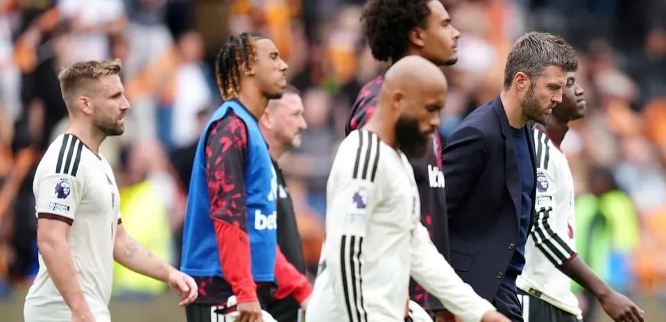 Football players and coach walking off the pitch