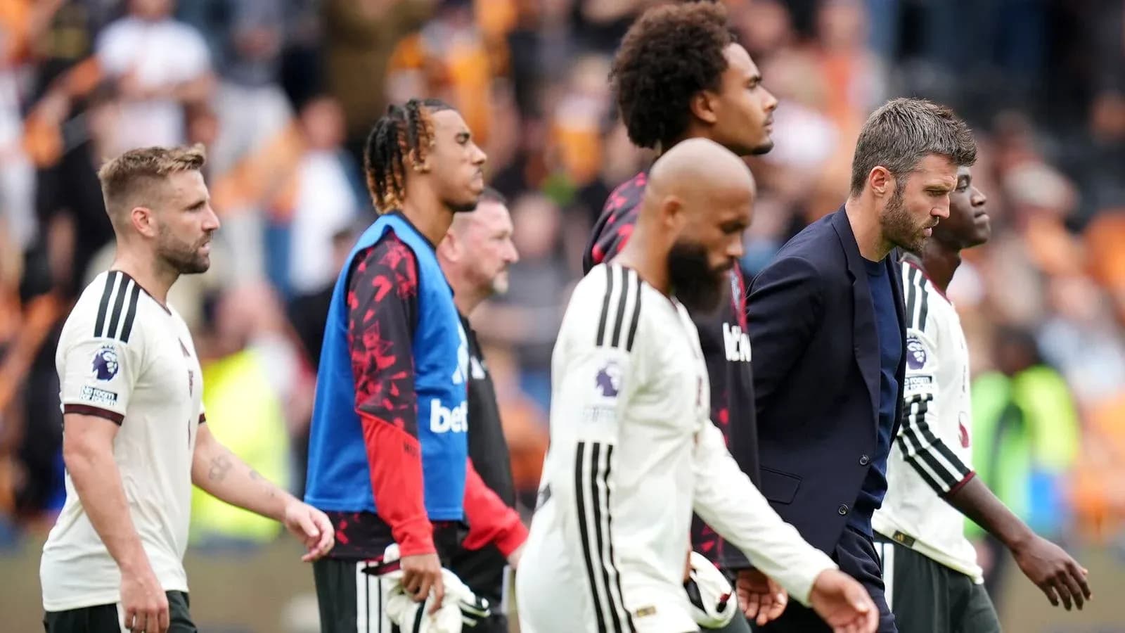 Football players and coach walking off the pitch