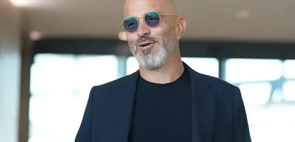 Man wearing sunglasses and a black suit