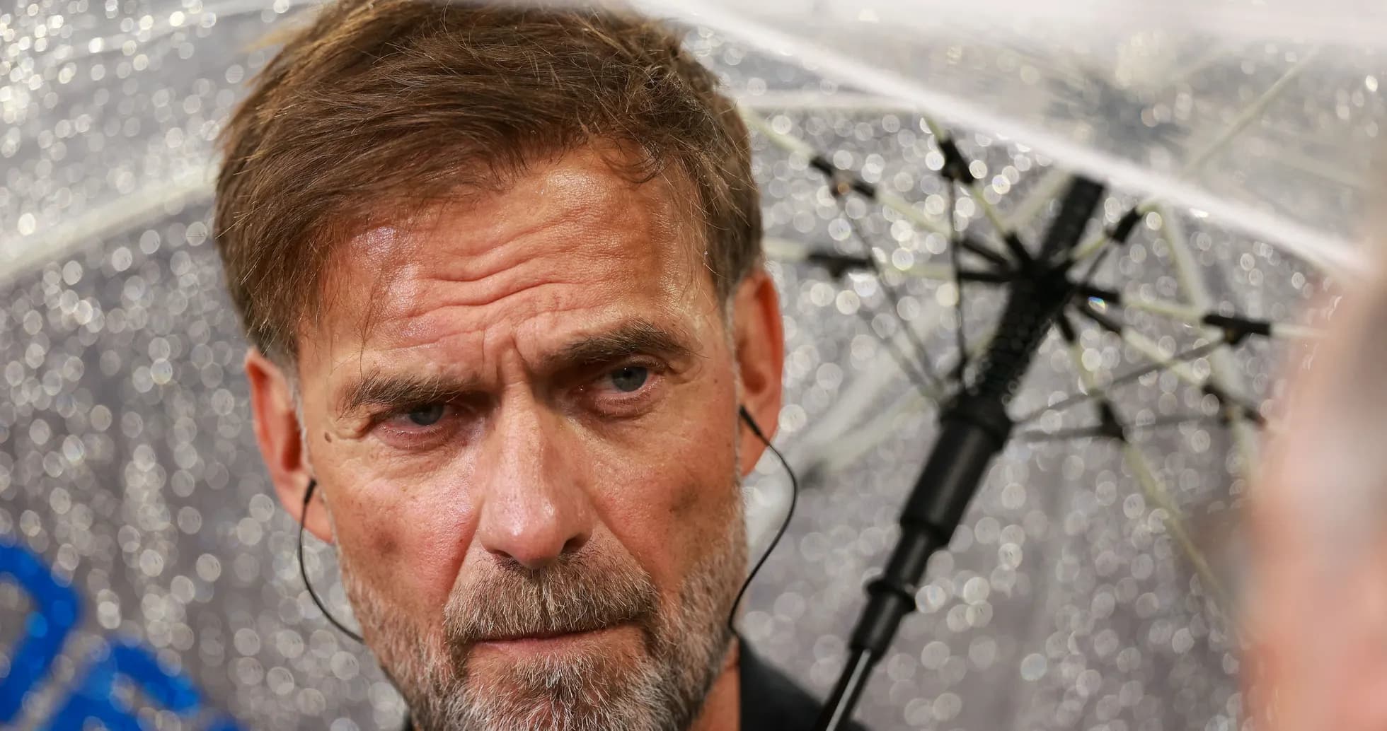 Man with umbrella during rainy press conference