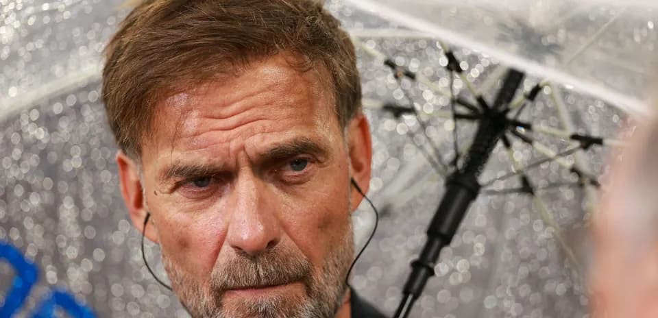 Man with umbrella during rainy press conference