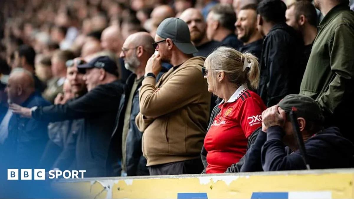 Fans watching the match in the stadium stands