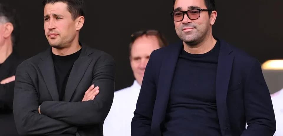 Two men seated in the stands watching a game