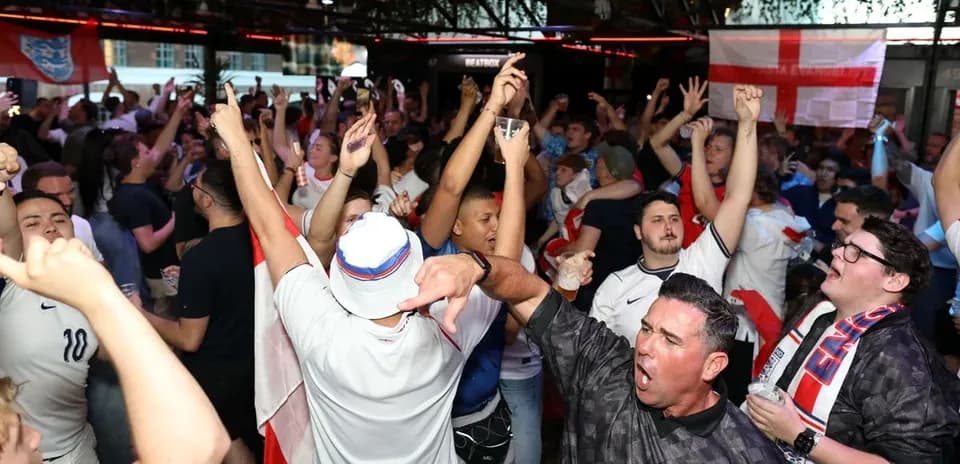 Fans celebrating in a crowded venue with drinks