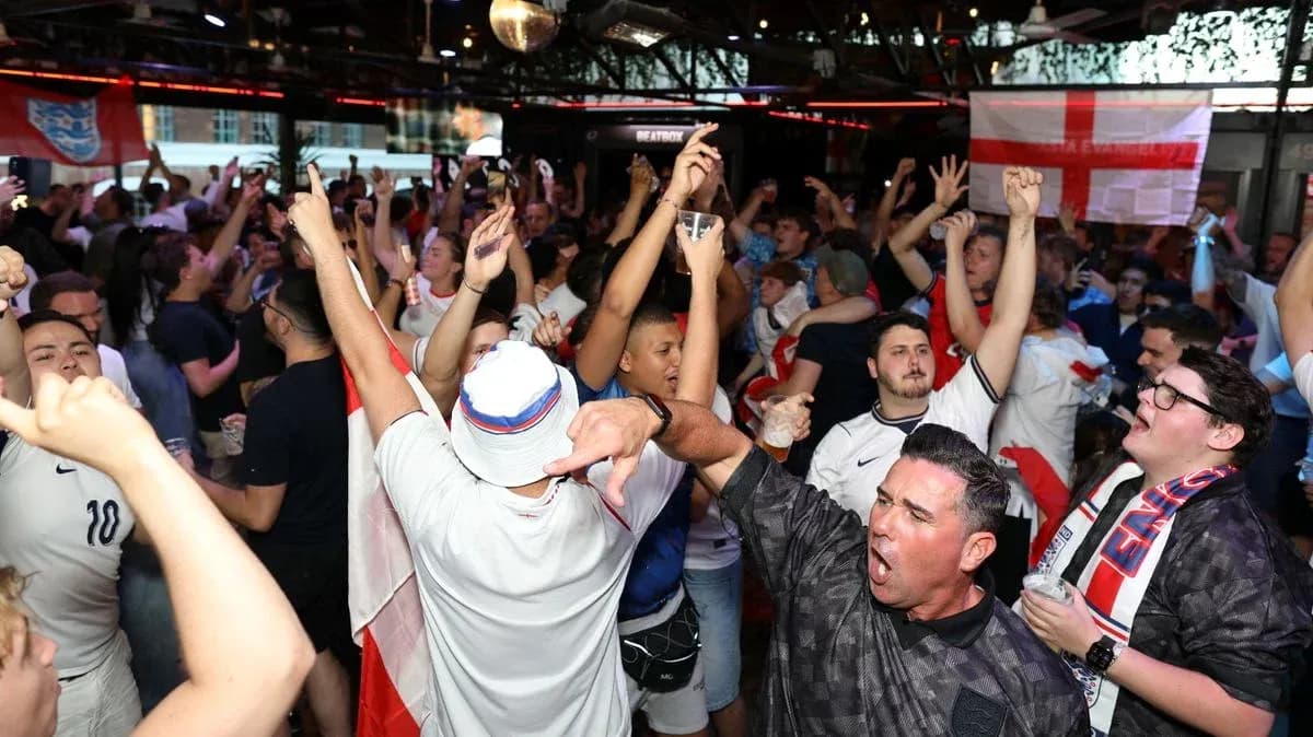 Fans celebrating in a crowded venue with drinks