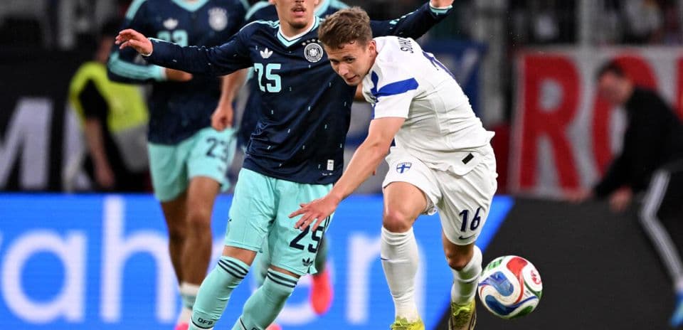 Finland player challenging Germany player for the ball
