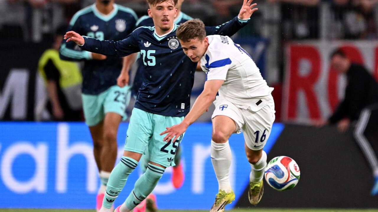 Finland player challenging Germany player for the ball