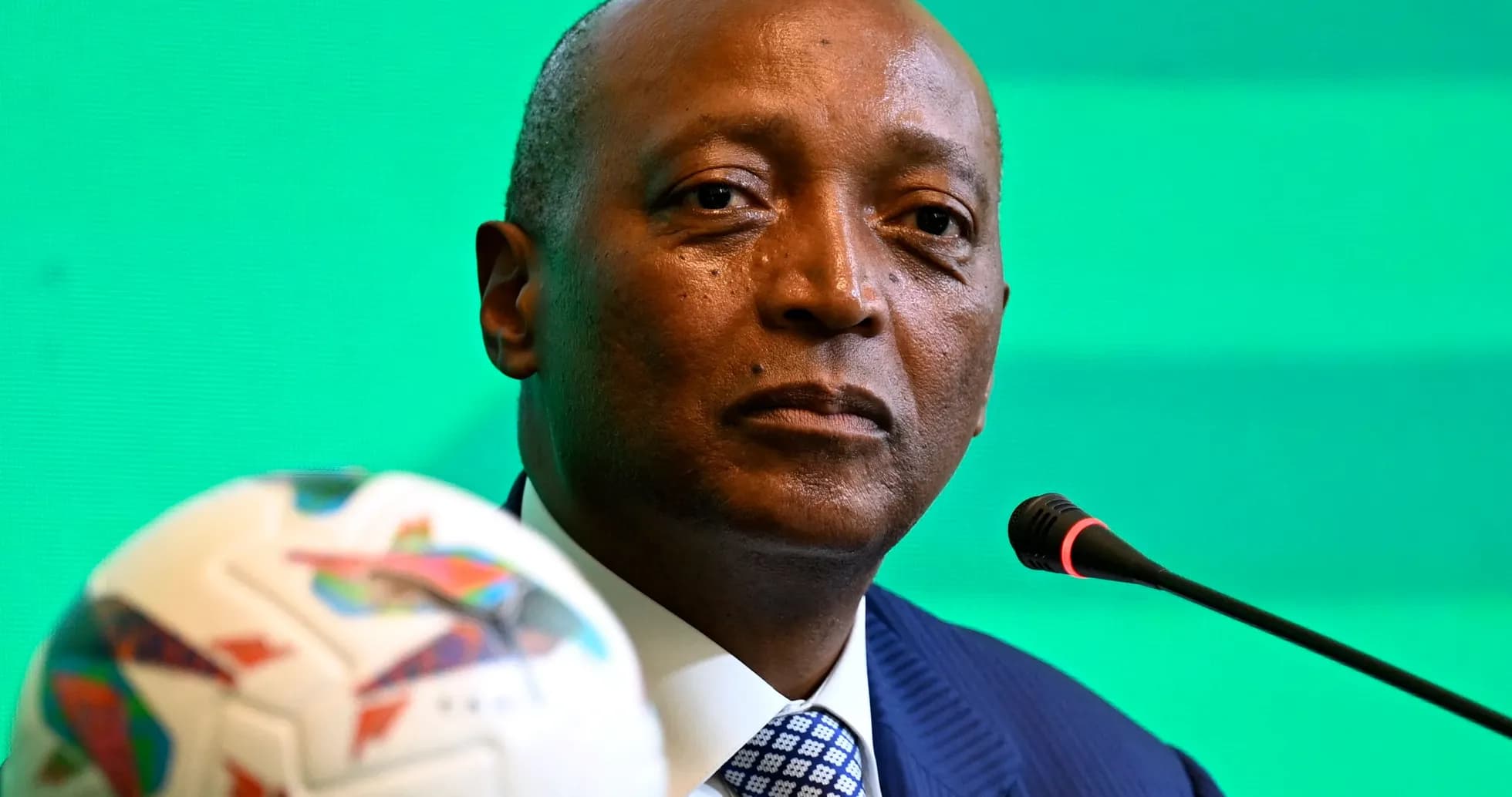 Official at press conference with soccer ball