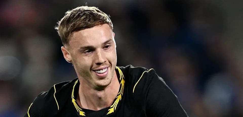 Futbolçu qara forma ilə gülərək meydanda
