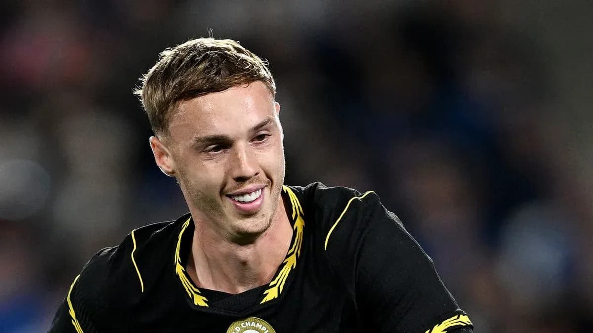Futbolçu qara forma ilə gülərək meydanda