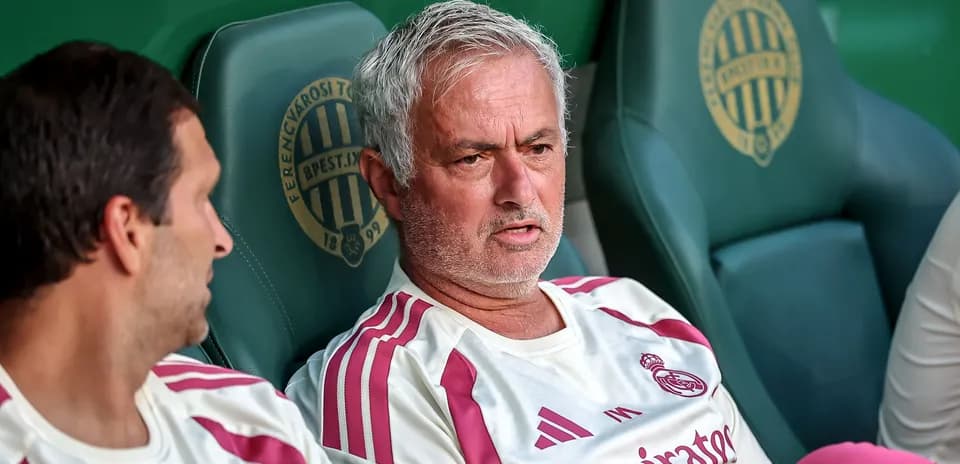 İki məşqçi oturacaqda, Ferencváros simgəsi arxada