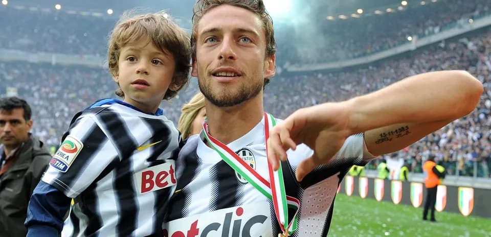 Futbolçu medal ilə uşağı qucağında tutub