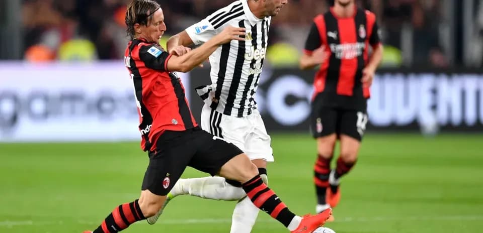 AC Milan player tackles Juventus player during match