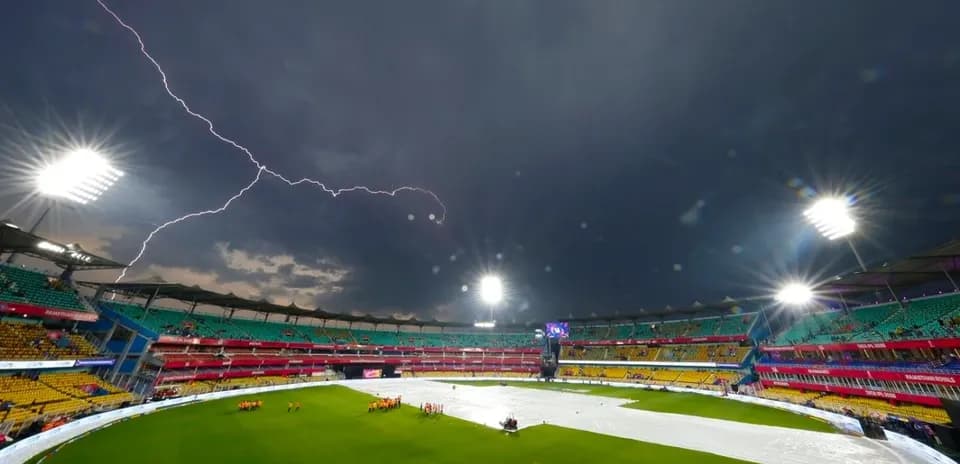 Lightning over cricket stadium with rain cover