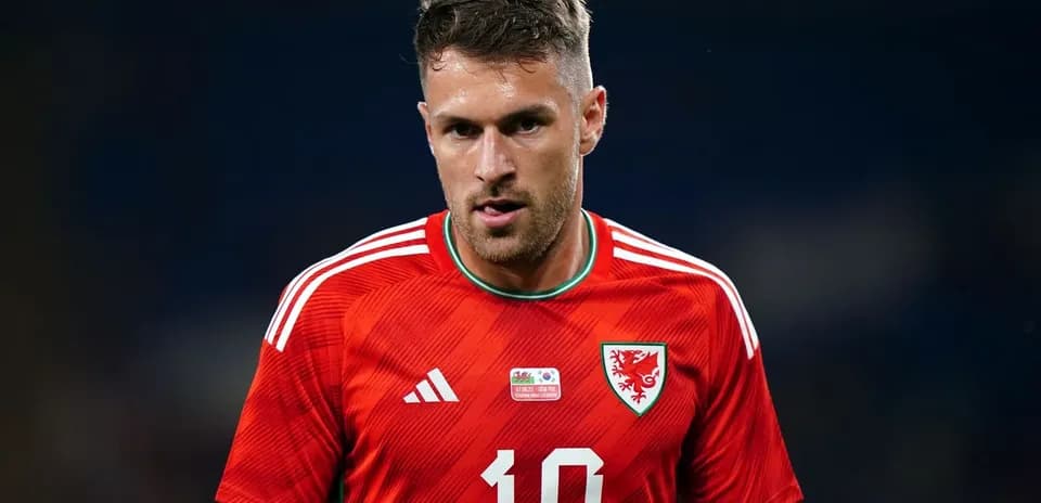 Futbolçu qırmızı formada meydanda yürüyür