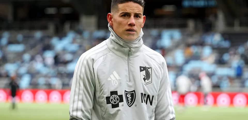 Futbolçu MNUFC geyimində sahədə dayanıb