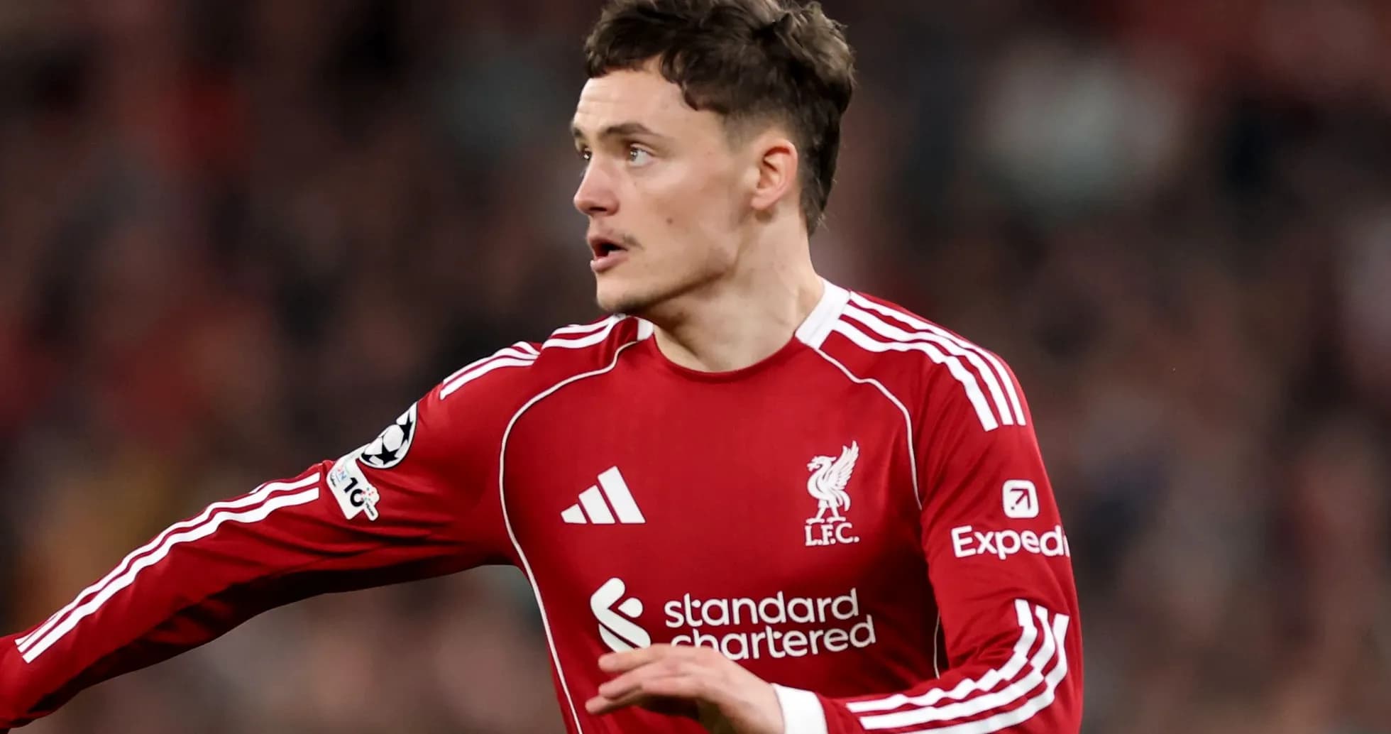 Futbolçu Liverpool formasında topa doğru hərəkət edir