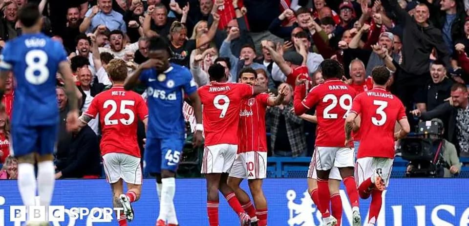 Players celebrating a goal with fans in background