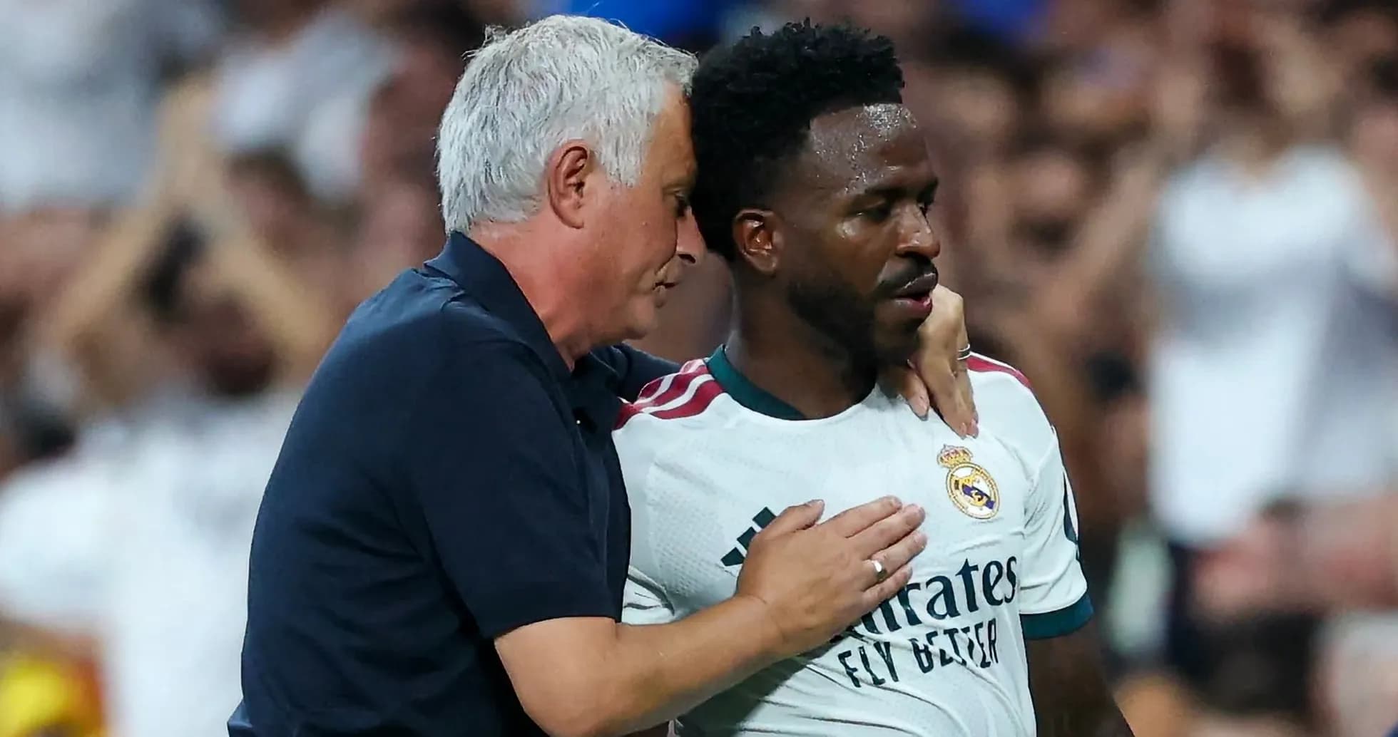 Coach speaking to player on the pitch