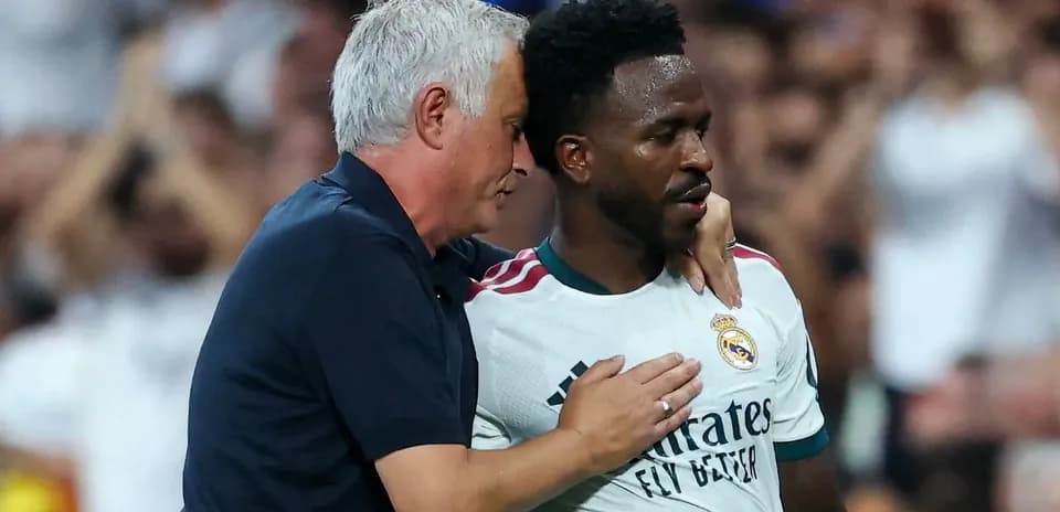 Coach speaking to player on the pitch