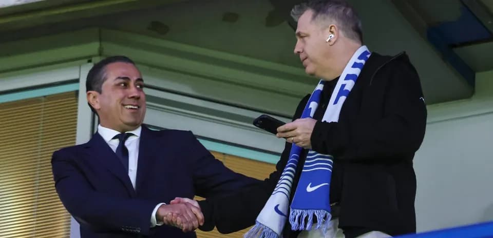 Two men shaking hands in stadium box