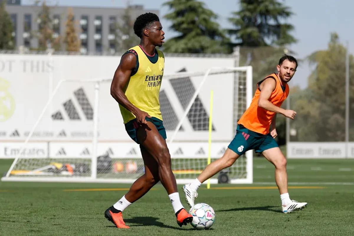 İki futbolçu məşq zamanı topu izləyir