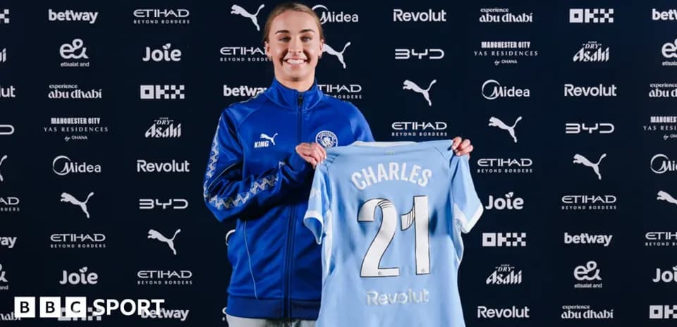 Player holding Manchester City jersey at presentation