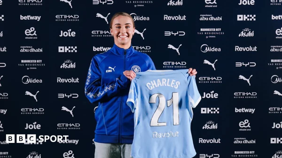Player holding Manchester City jersey at presentation