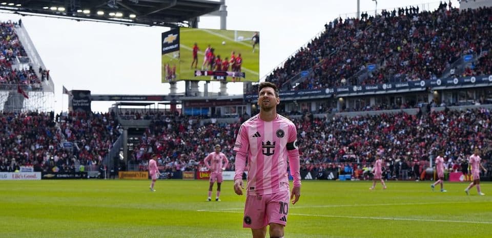 Lionel Messi on field during match with fans