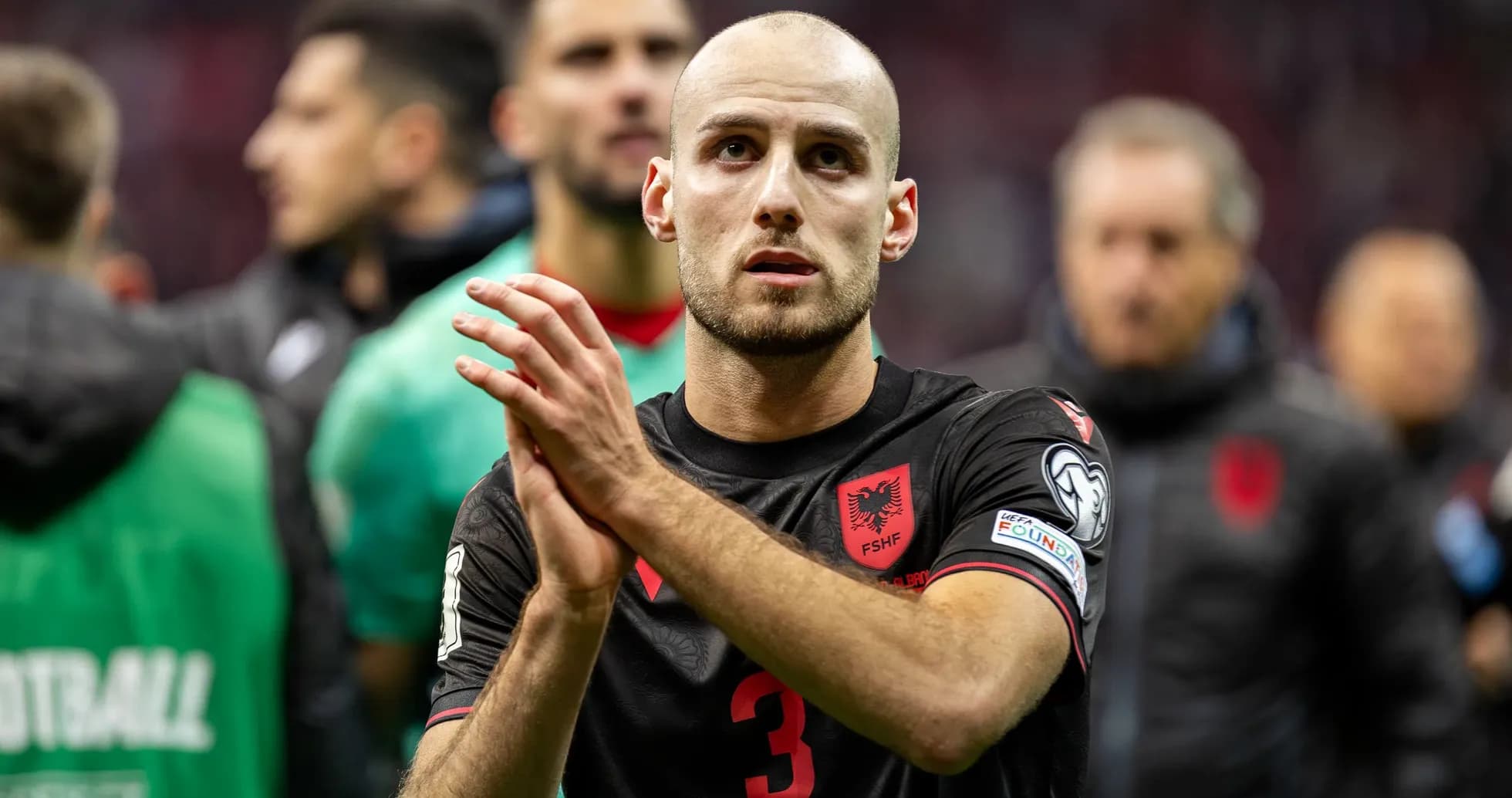 Futbolçu əl çəkməkdə, arxa planda komanda yoldaşları