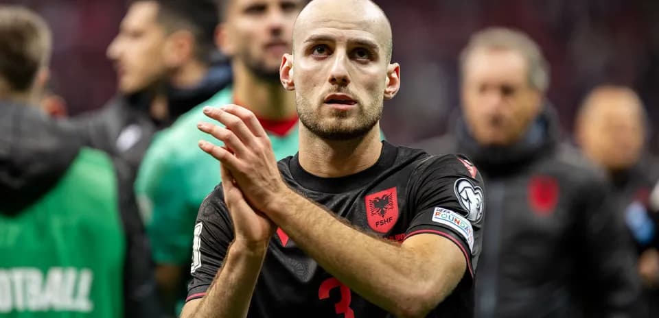 Futbolçu əl çəkməkdə, arxa planda komanda yoldaşları