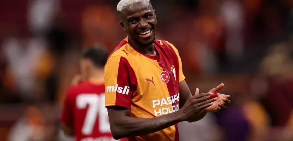 Futbolçu Galatasaray formasında gülərək alqışlayır