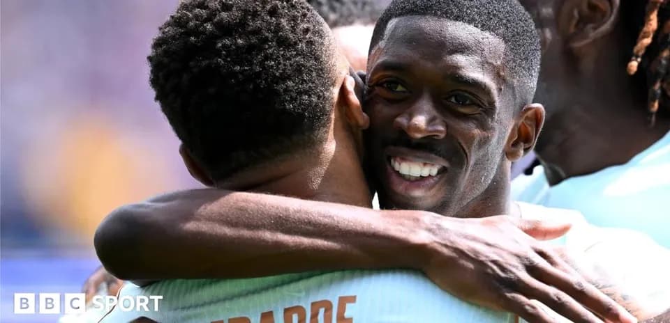 Two players celebrating with a hug on the field
