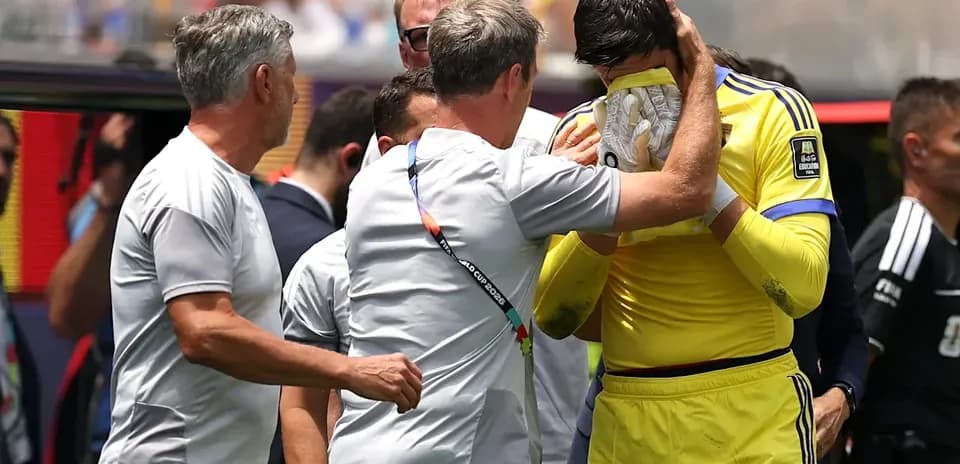 Coach comforting goalkeeper during match break
